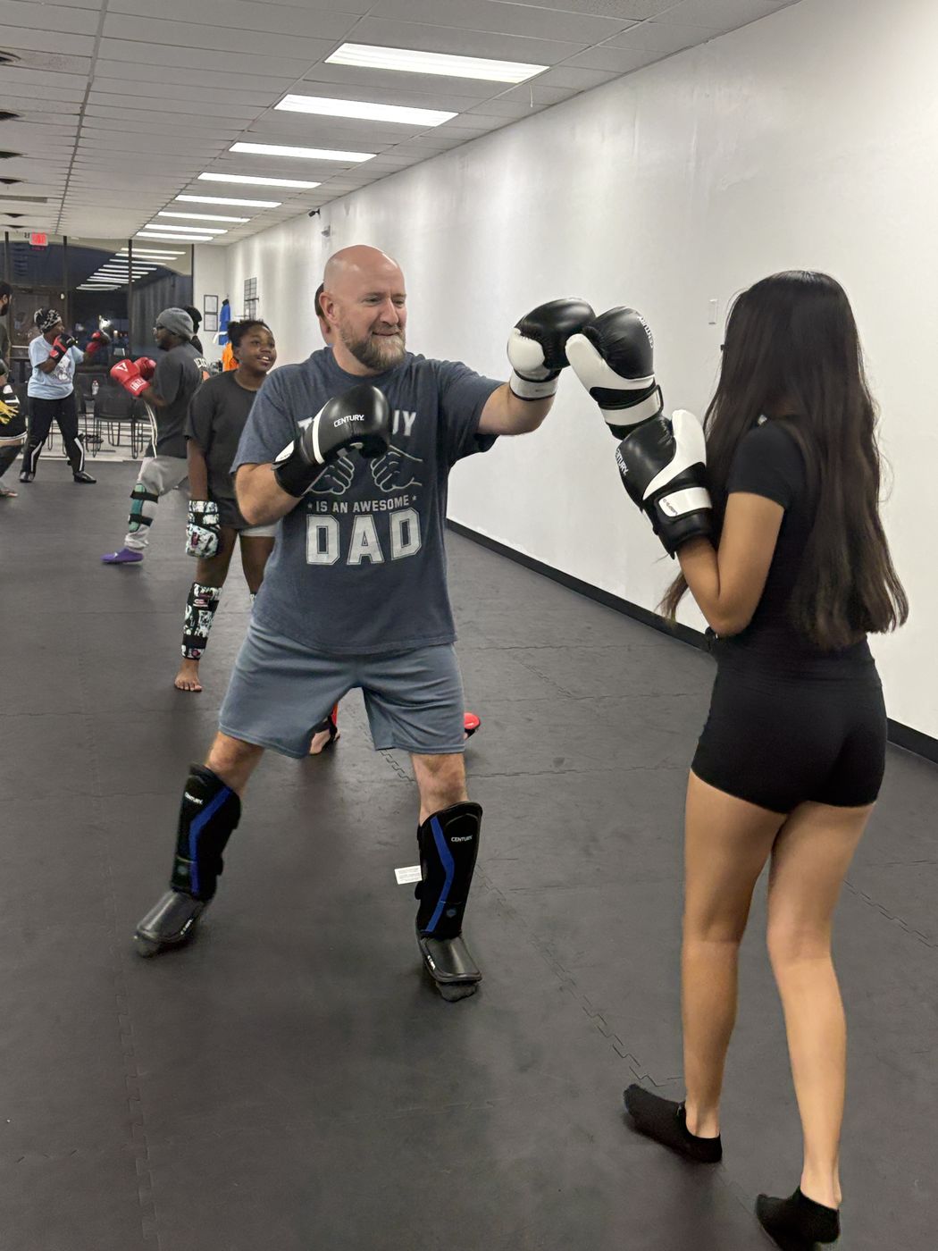 Adults training a partner drill in gloves and shin guards at Legacy Martial Arts kickboxing in Salisbury, Maryland