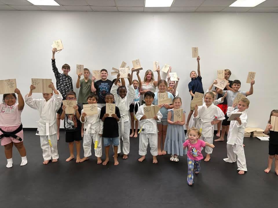 Legacy Martial Arts students celebrating after a board breaking session